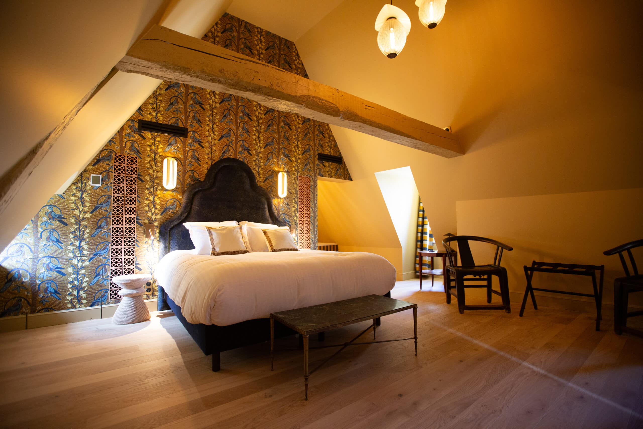 Hôtel La Particulière — Attic suite with exposed beams, large king-size bed and refined decor; authentic charm and boutique comfort